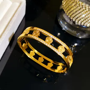 Gedetailleerde weergave van een gouden titanium stalen armband met madeliefjes en fonkelingen
