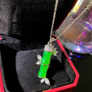 Close-up detail of a luxury green faux jade bamboo pendant necklace in a red jewelry box