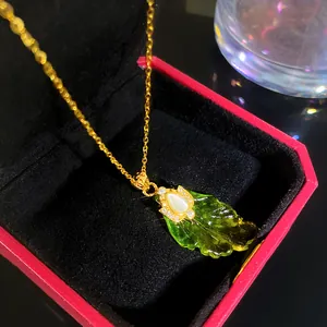 Macro detail of elegant green leaf pendant necklace with sparkling stone accents