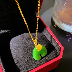 Close-up of a green Ruyi faux jade pendant necklace presented in a red gift box.