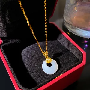 Close-up of a white imitation jade Ping An Kou pendant with a gold chain in a luxury red box