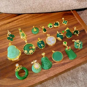 Collection of Chinese style green jade pendants with gold accents on a wooden tray