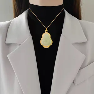 Macro view showing the intricate detail of the gold gourd pendant necklace with jade stones