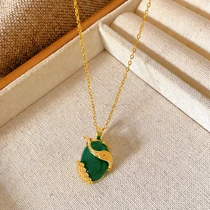 Close-up of a gold-plated necklace featuring a vintage green stone pendant with zircon.