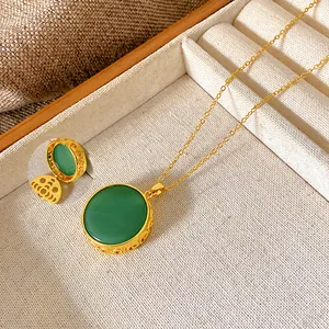 Detail view of vintage gold necklace featuring a large circular green gemstone pendant