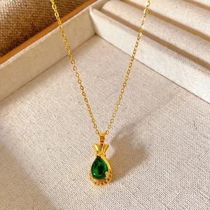 Detailed view of golden titanium steel necklace with green lucky bag pendant in a tray