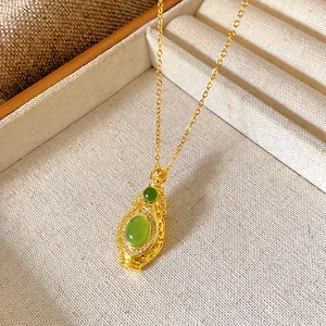 Detailed macro view of a vintage gold gourd pendant featuring elegant green zircon inlay