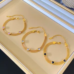 Detailed view of three gold mesh bracelets featuring pink, blue, and black heart stones.
