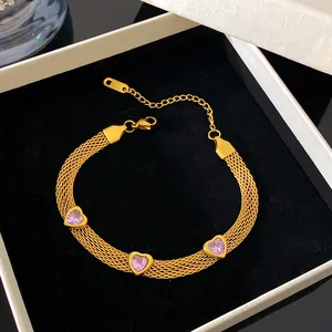 Detailed macro view of the gold mesh bracelet with heart-shaped pink crystal gems