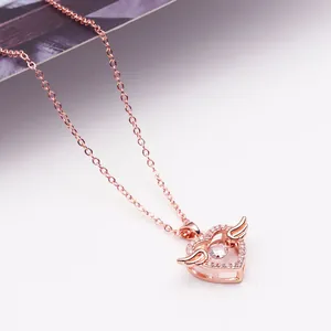 Detailopname van roségouden engel hart hanger met fonkelende dansende steen en zirkonia's.