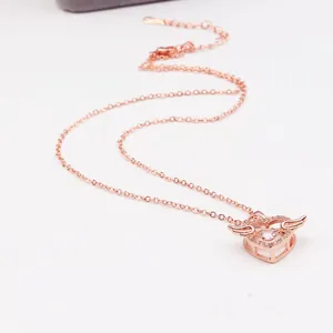 Gedetailleerde macro-opname van roségouden engel hart ketting met fonkelende zirkoon