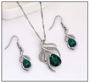 Detailansicht eines silbernen Schmucksets mit eleganten grünen Tropfensteinen.