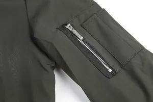 Close-up of olive green jacket sleeve with functional zipper pocket detail.