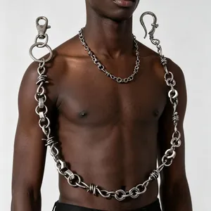 Détail d'une chaîne à nœuds d'épines en métal lourd portée par un mannequin homme.