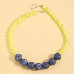Dettaglio di una collana di perle acriliche in stile mirtillo con perle gialle
