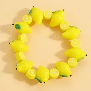 Dettaglio macro di un braccialetto in acrilico giallo con perline a forma di limone