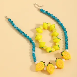 Primo piano di perle blu e ciondoli a forma di limone giallo di un set di gioielli