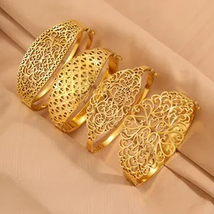 Gedetailleerd overzicht van vier gouden filigraan armbanden op luxe zachte zijden stof