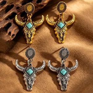 Dettaglio orecchini vintage a teschio di toro con turchese in finitura oro e argento