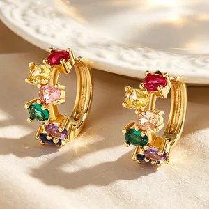 Macro detail of elegant gold hoop earrings featuring vibrant multi-colored oval zircon stones