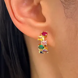 Close-up of gold ear hoop featuring vibrant multi-colored oval zircon stones