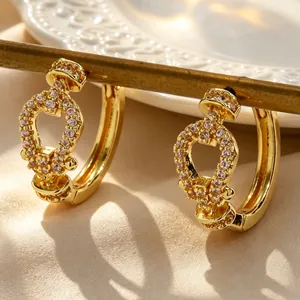 Detail view of elegant gold-plated hoop earrings with pink crystal horseshoe buckles.