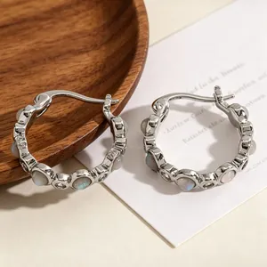 Close-up detail of high-quality silver hoop earrings with vintage opal and zircon stones