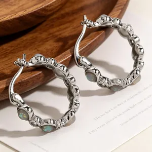 Close-up of vintage silver hoop earrings with iridescent opal-style stones