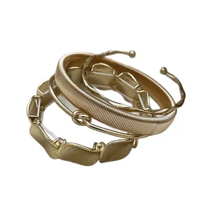 Elegant set of 3 gold geometric bangles including textured and irregular leaf designs