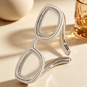 Gros plan détaillé d'une bague ouverte créative en argent en forme de lunettes