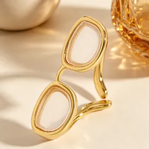 Gros plan détaillé sur une bague créative dorée en forme de lunettes miniatures