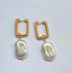 Detailed view of gold rectangular hoop earrings adorned with crystals and baroque pearls