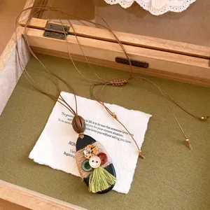 Handgemaakte Boheemse ketting met een zwarte ovale hanger en een opvallende groene kwast