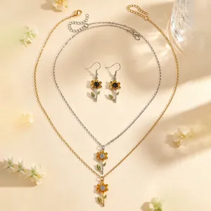 Detailansicht des Sonnenblumen-Halsketten- und Ohrring-Sets in Gold- und Silberoptik.