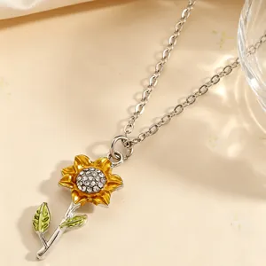 Detailaufnahme eines silbernen Sonnenblumenanhängers mit gelben Blättern und Kristallen