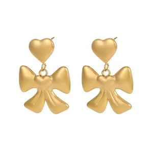 Detail view of premium matte 18K gold plated heart and bow-knot dangle earrings