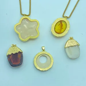 Detail showing various vintage resin pendants with gold-plated textured borders