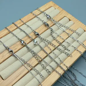 Close-up detail of various stainless steel DIY necklace chains on wooden display