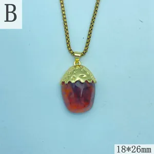 Close-up of vintage resin amber pendant with a gold-plated textured acorn cap detail.