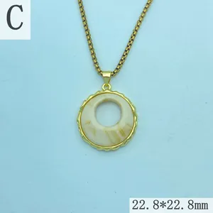 Close-up of retro resin amber pendant necklace with gold plated scalloped edge