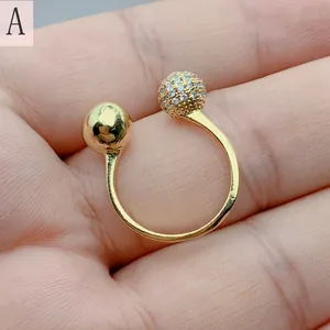 Close-up of gold-plated open ring with zircon and polished sphere detail on hand