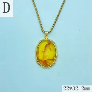 Macro view of a vintage oval amber resin pendant featuring an irregular gold frame.