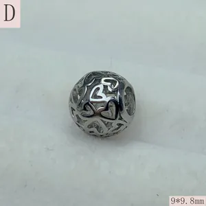 Close-up detail of a retro hollow-out stainless steel round spacer bead with heart patterns
