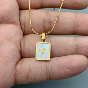 Nahaufnahme von goldenem Widder-Sternzeichen-Anhänger mit Perlmutt auf Edelstahlkette