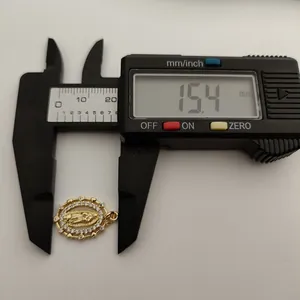 Measurement detail of a gold Virgin of Guadalupe pendant showing 15.4mm diameter