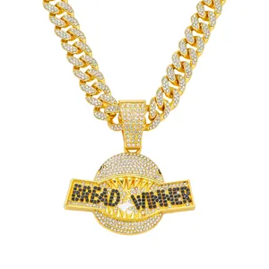 Gedetailleerde close-up van gouden haaienbek hanger met Bread Winner tekst in strassteentjes