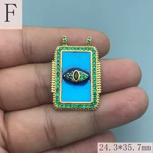 Nahaufnahme eines vintage blauen Emaille Evil Eye Anhängers mit grünen Kristallen für DIY.
