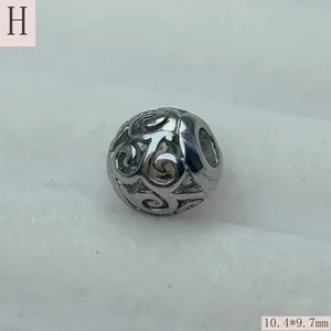 Macro view of a retro silver hollow stainless steel scroll pattern bead for DIY jewelry making