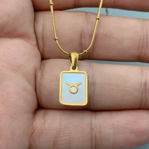 Detailansicht einer Stier-Sternzeichen-Halskette mit Muschel-Inlay auf einer Goldkette