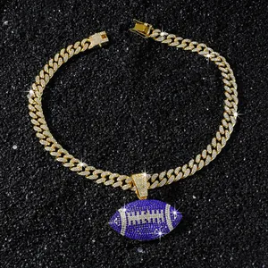 Close-up of iced-out gold Cuban chain and blue football pendant with rhinestones.